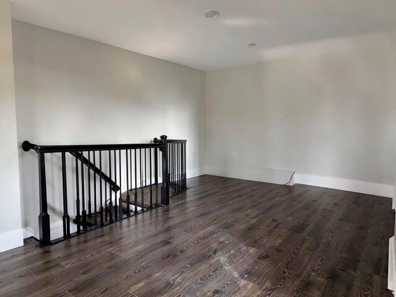 Dry finished basement with dark wood-look flooring